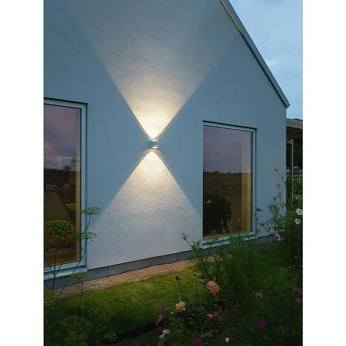 Konstsmide LED-Außenwandleuchte Bitonto - 11 W, 12 x 10,5 x 12 cm, Weiß, IP54 - Außenaufnahme einer modernen, an der Wand montierten Außenleuchte, die ein dekoratives Lichtmuster erzeugt und die Architektur hervorhebt.