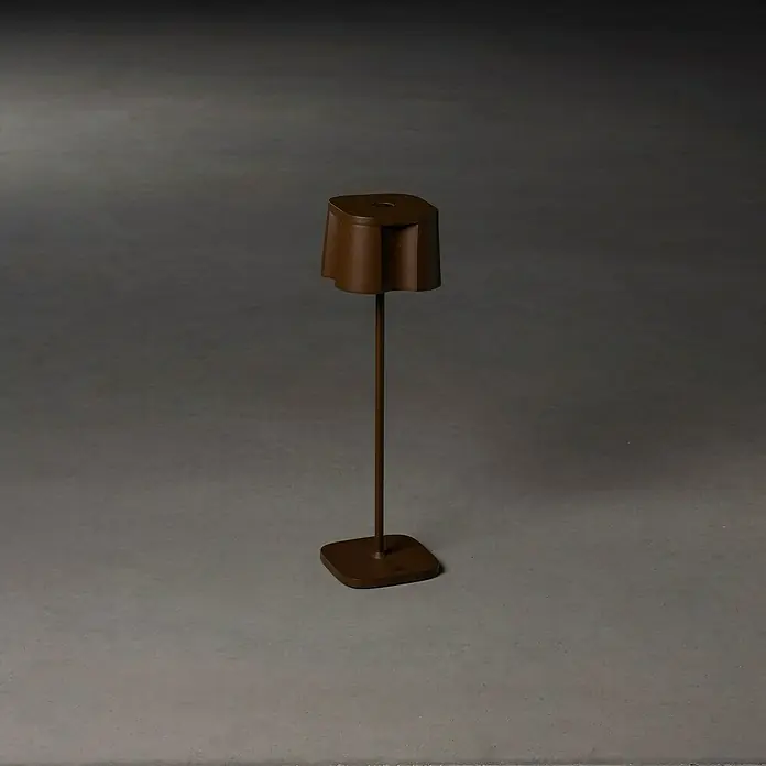 Konstsmide Akku-Tischleuchte Nice - 2,5 W, L x B x H: 10 x 10 x 36 cm, Rost, Warmweiß - Elegante Stehleuchte mit skulpturalem Lampenschirm und minimalistischem Design. Passt perfekt in moderne Wohnräume und sorgt für angenehmes Licht.