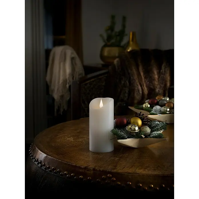 Konstsmide LED-Echtwachskerze - Ø x H: 7,5 x 15,5 cm, Weiß - Elegante LED-Kerze auf rustikalem Tisch mit Weihnachtsdeko. Warmes Licht sorgt für eine gemütliche Atmosphäre im Raum. Perfekt für die festliche Saison.
