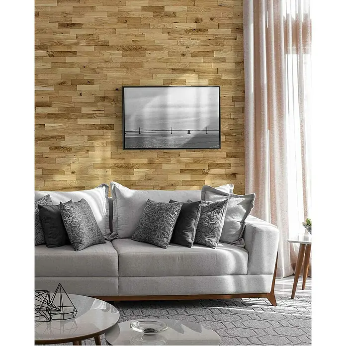Wodewa Holzriemchen 200 Eiche rustikal - 100 Stk., L x B: 200 x 50 mm, 2 mm - 6 mm, Max. Anwendungsfläche: 1 m², Strukturiert UV-geölt - Graues Sofa mit Zierkissen vor einer Holzwand mit einem gerahmten Bild. Stilvolles Wohnzimmerdesign mit modernem Touch und eleganten Textilien.