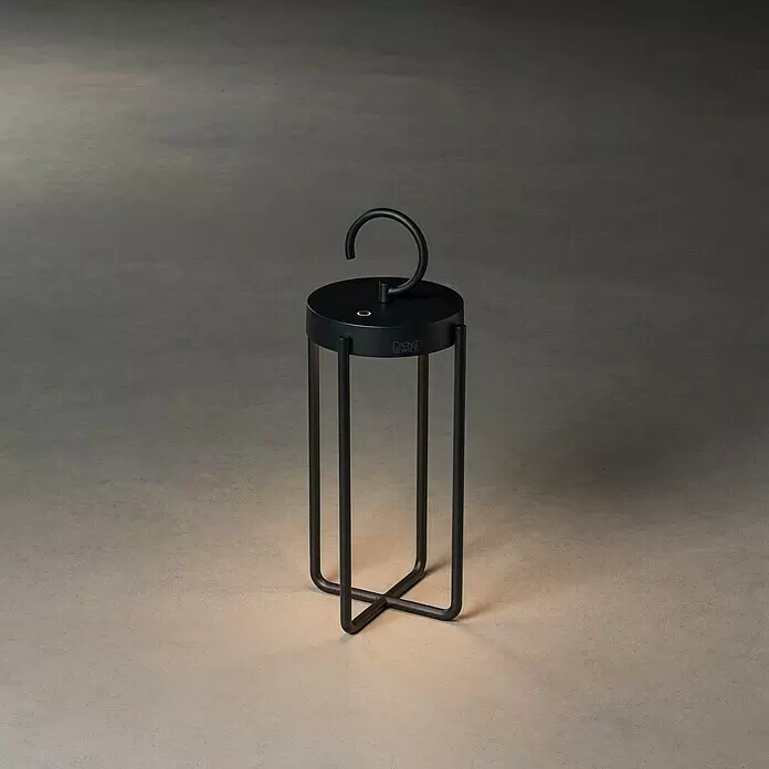 Konstsmide Außenlaterne Manorola - 15,5 x 15 x 39 cm, Schwarz - Schwarze tragbare Laterne mit Haken und warmem Licht, das vom Boden aus strahlt.
