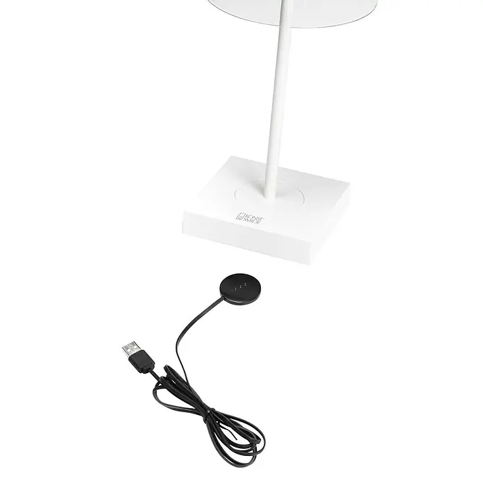 Konstsmide Akku-Tischleuchte Scilla - 2,5 W, L x B x H: 11 x 11 x 27 cm, Weiß, Warmweiß - Das Bild zeigt eine weiße Schreibtischlampe mit einem quadratischen Sockel und einem USB-Ladegerät, das daneben liegt.