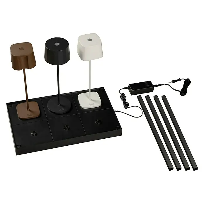 Konstsmide Ladestation für USB-Tischleuchten - 6 Ladeplätze - Drei Tischlampen in verschiedenen Farben (Braun, Schwarz, Weiß) auf einer schwarzen Basis mit zugehörigem Zubehör.