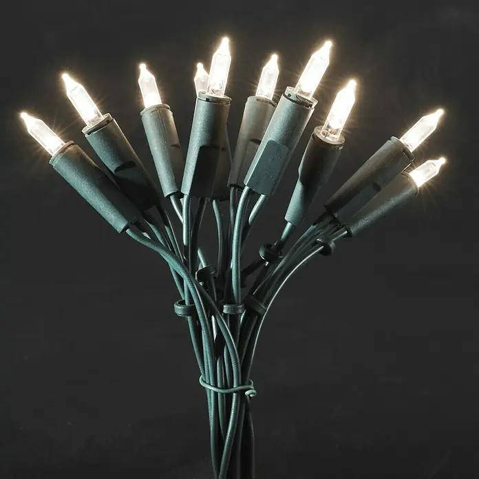 Konstsmide LED-Lichterkette Mini - Innen, Lichtfarbe: Warmweiß, Anzahl Leuchtmittel: 20 Stk., Netzbetrieben - Bild einer gebündelten Lichterkette mit warmweißen Lichtern und grünem Kabel vor einem dunklen Hintergrund.