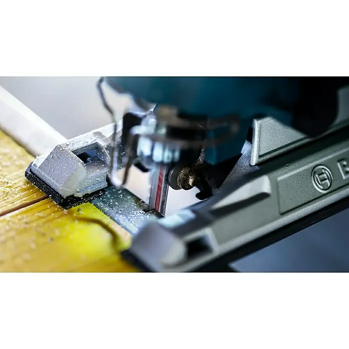 Bosch Expert Stichsägeblatt Multi Material T 367 XHM - Holz/Metall/Kunststoff, T-Schaft - Nahaufnahme einer Stichsäge von Bosch, die ein gelbes Holzbrett durchsägt, wobei Sägespäne entstehen. Werkzeug im Einsatz mit Fokus auf das Sägeblatt.