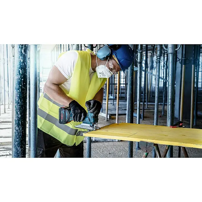 Bosch Expert Stichsägeblatt Multi Material T 367 XHM - Holz/Metall/Kunststoff, T-Schaft - Ein Bauarbeiter in Schutzkleidung benutzt eine Bosch Akku-Stichsäge, um ein gelbes Brett zu schneiden.