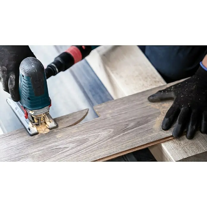 Bosch Stichsägeblätter Laminate Clean T 128 BHMT-Schaft - Ein Arbeiter schneidet mit einer Stichsäge ein Laminatstück. Die Stichsäge von Bosch ist gut sichtbar und wird fachmännisch eingesetzt.