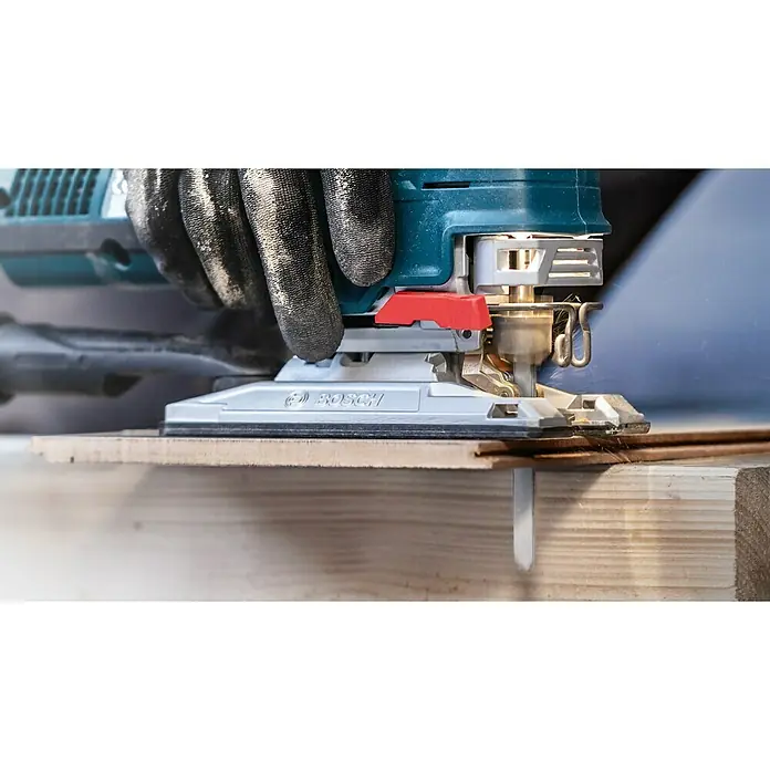 Bosch Stichsägeblätter Laminate Clean T 128 BHM - T-Schaft - Eine Nahaufnahme einer Bosch Stichsäge in Aktion, die ein Holzbrett sägt, wobei eine behandschuhte Hand die Säge führt.