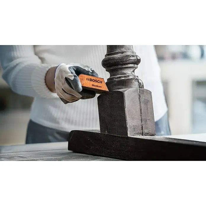 Bosch Professional Expert Schleifschwamm S473 - 120 x 98 x 13 mm, Korngröße: Sehr Fein, 1 Stk. - Person schleift mit einem Bosch Schleifklotz „Medium“ ein Holzstück. Ideal für das Schleifen von Holz, Kunststoff oder Farbe.