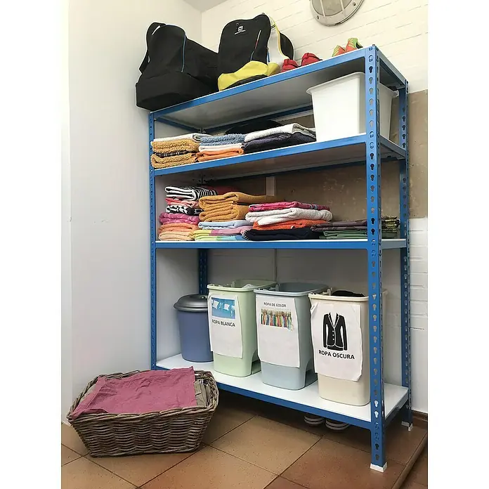 Simonrack Simonclick Metallregal Simonclick Mini - H x B x T: 150 x 80 x 40 cm, Traglast pro Boden: 180 kg, Anzahl Böden: 4 Stk., Stecken, Blau/Weiß - Waschküche mit einem blauen Metallregal, das mit gefalteten Handtüchern, Behältern und einem Wäschekorb mit rosa Stoff gefüllt ist.