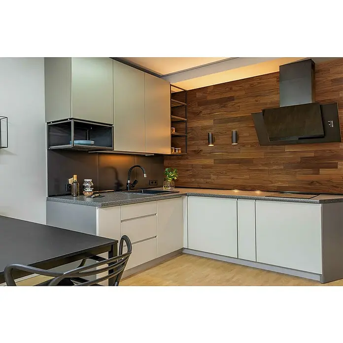 Wodewa Holzriemchen 1000 Nussbaum - 1.000 x 100 mm, Stärke: 3 mm - 6 mm, 10 Stk., 1 m², Selbsklebend - Moderne Küche mit grauen Schränken, einer Arbeitsplatte in Steinoptik und einer hölzernen Akzentwand mit Dunstabzugshaube.