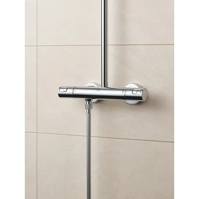 Grohe Vitalio Start Duschsystem 250 - Mit Thermostatarmatur, Lochabstand: 101,6 cm, Anzahl Strahlarten: 2 Stk., Chrom - Nahaufnahme einer glänzenden Grohe Duscharmatur an einer Wand mit Fliesen.