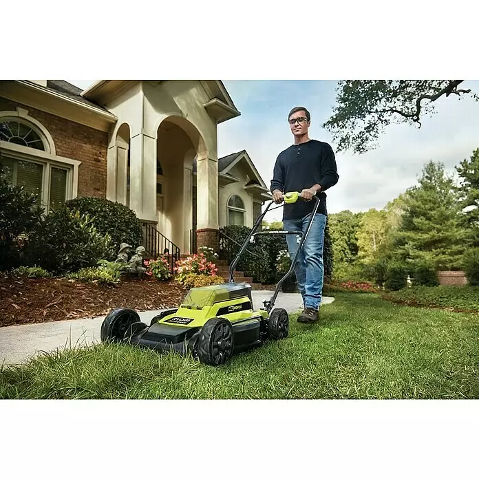 Ryobi Akku-Rasenmäher RY36LMM46A-140 - 36 V, 1 Akku, 4 Ah, Schnittbreite: 46 cm - Mann mäht Rasen mit einem grünen und schwarzen Ryobi Akku-Rasenmäher vor einem Haus.