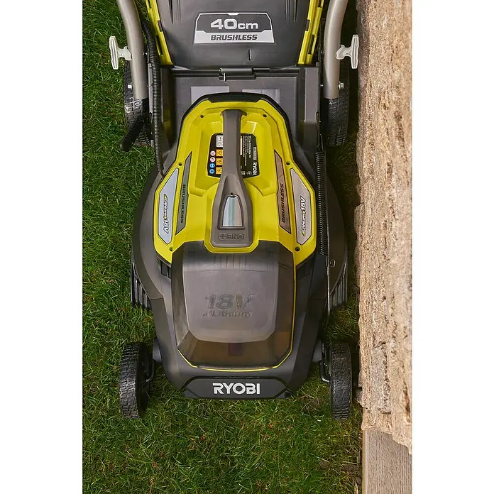 Ryobi ONE+ Akku-Rasenmäher RY18LMX40A-240 - 18 V, 2 Akkus, 4 Ah, Schnittbreite: 40 cm - Draufsicht auf einen Ryobi 40cm Akku-Rasenmäher mit bürstenlosem Motor, der auf einer Rasenfläche neben einer Mauer steht.
