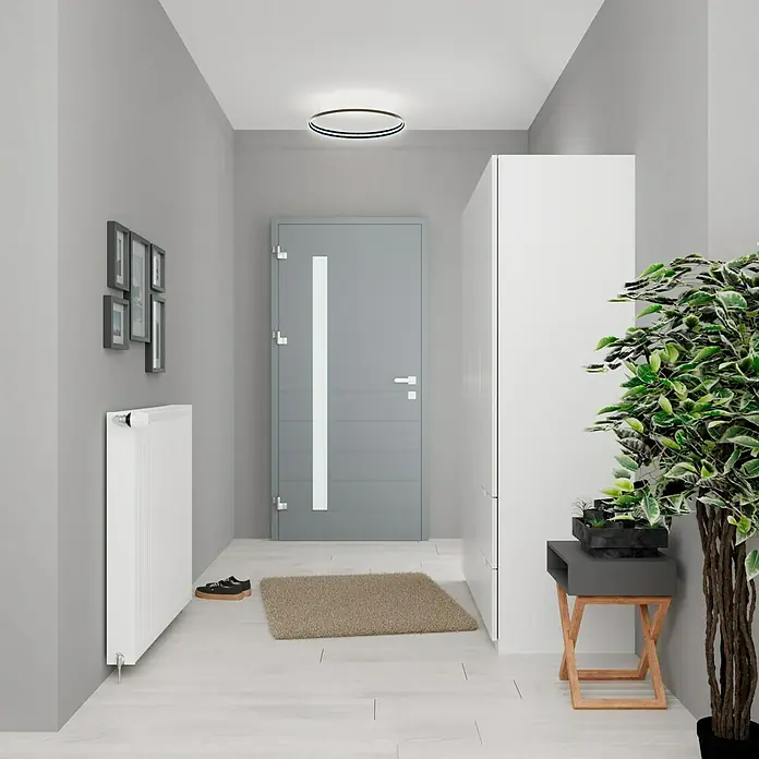 De'Longhi KompaktheizkörperB x H: 80 x 50 cm, Wärmeleistung bei Vorlauftemperatur von 75 °C (D: 50): 1.188 W, Typ Heizkörper: 22 - Eingangsbereich mit grauer Tür, weißem Heizkörper, runder Deckenleuchte und Dekorationen. Das freundliche Design lädt zum Betreten ein.