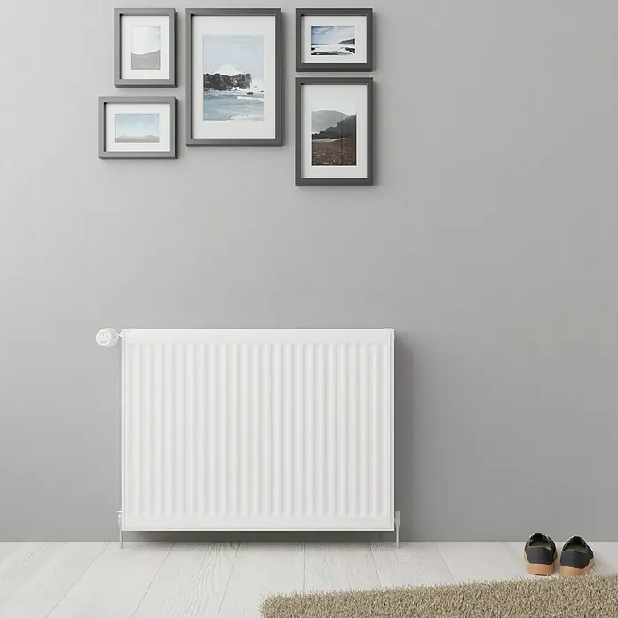 De'Longhi KompaktheizkörperB x H: 80 x 60 cm, Wärmeleistung bei Vorlauftemperatur von 75 °C (D: 50): 1.376 W, Typ Heizkörper: 22 - Grauer Raum mit einem weißen Heizkörper an der Wand und einigen Bildern darüber.