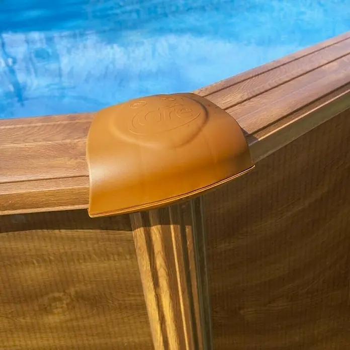 Gre Piscina de acero desmontable Mauritius - L x An x Al: 610 x 375 x 132 cm, Marrón claro, 23.281 l - Primer plano de una pieza de esquina de plástico marrón unida a un marco de piscina de madera, con logotipo.