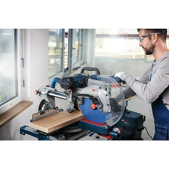 Bosch Kreissägeblatt Expert for Wood - 260 mm, Bohrung: 30 mm, Anzahl Zähne: 60 Stk. - Ein Mann bedient eine Bosch Kapp- und Gehrungssäge GCM 8 SJL zum Zuschneiden von Holz, mit Schutzbrille und Gehörschutz für sicheres Arbeiten.