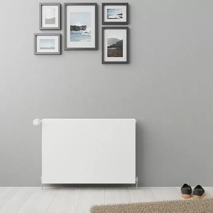 E.C.A. Planheizkörper - B x H: 800 x 550 mm, 1.247 W, 22 - Weißer Plattenheizkörper mit Thermostatknopf an einer Wand in einem modernen Raumumgebung.