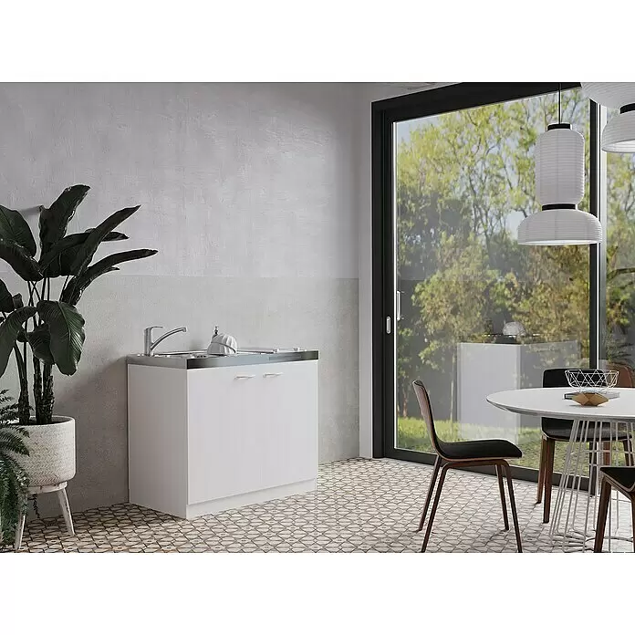 Respekta Miniküche Levin - 100 cm, Weiß, Kochfeld - Weißer Spülunterschrank mit Edelstahloberfläche und Wasserhahn in einem modernen Raum mit gemustertem Boden und großem Fenster.