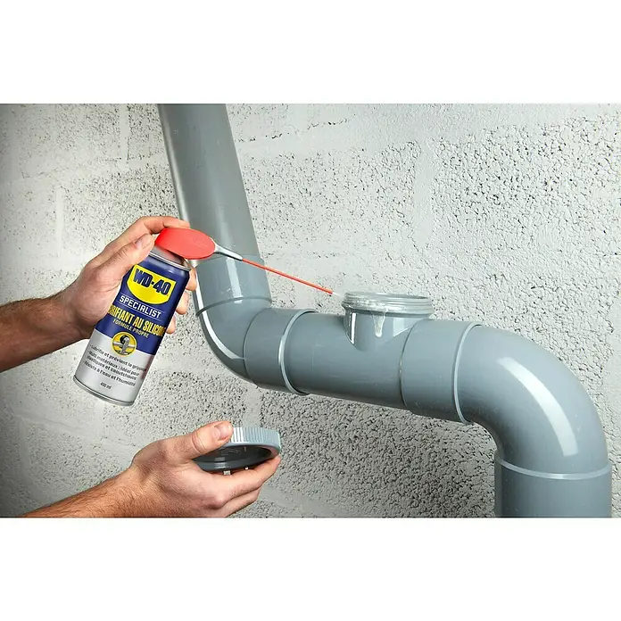 WD-40 Specialist Spray lubricante de silicona - 400 ml - Se está aplicando WD-40 Specialist Silicone Spray a un tubo de plástico gris para lubricarlo y protegerlo de daños.