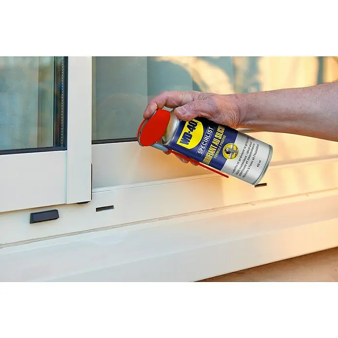 WD-40 Specialist Spray lubricante de silicona - 400 ml - Una lata de spray de silicona WD-40 está siendo rociada sobre el marco de una ventana.