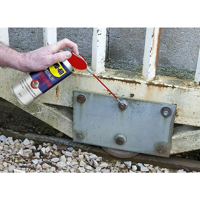 WD-40 Specialist Penetrante antióxido de acción rápida - 400 ml - Uso de WD-40 Specialist Desengrasante en una puerta metálica, apuntando a los pernos oxidados para aflojar y mejorar el movimiento.