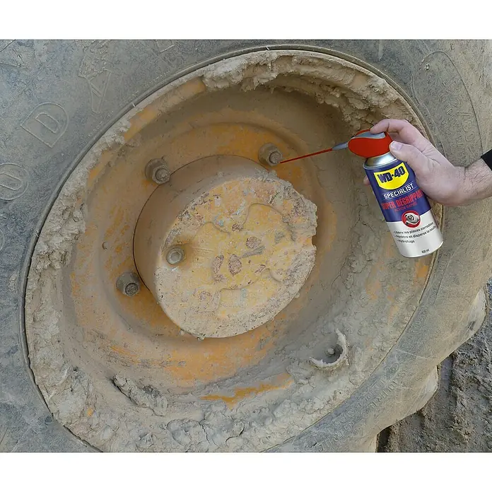 WD-40 Specialist Penetrante antióxido de acción rápida - 400 ml - Se está rociando un WD-40 Specialist Super Degrippant en una llanta sucia para aflojar las piezas corroídas.