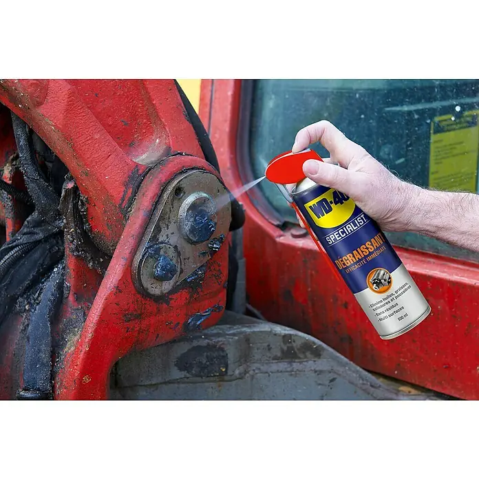 WD-40 Specialist Limpiador desengrasante - 500 ml - Se está rociando desengrasante WD-40 Specialist sobre una estructura metálica roja, para quitar el aceite y la suciedad.