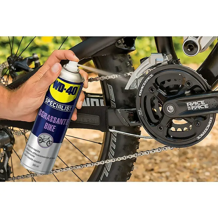 WD-40 Bike Lubricante - 500 ml - Primer plano de una persona rociando desengrasante para bicicletas WD-40 Specialist en una cadena de bicicleta.