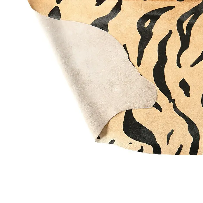 Esbeco Kuhfell - 100 % Echtfell, Tiger - Detailansicht eines Tigerfellteppichs, der die Textur und das Muster des Teppichs hervorhebt. Perfekt für die moderne Raumgestaltung.