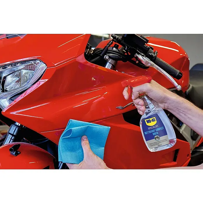 WD-40 Specialist Limpiador Total - 500 ml - Una moto roja limpiada con WD-40 Specialist Limpiador Completo Moto y un paño de microfibra azul para brillo y limpieza.