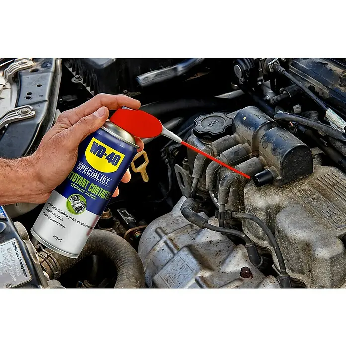 WD-40 Specialist Limpiador de contactos de secado rápido - 400 ml - Primer plano del Limpiador de Contactos WD-40 Specialist utilizado en un motor de coche, ayudando en la limpieza y el mantenimiento.