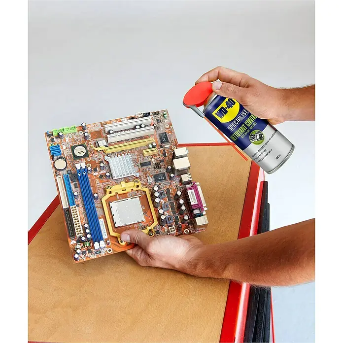 WD-40 Specialist Limpiador de contactos de secado rápido - 400 ml - Una lata de Limpiador de Contactos Especialista WD-40 se rocía sobre una placa de ordenador para eliminar la grasa y la suciedad.