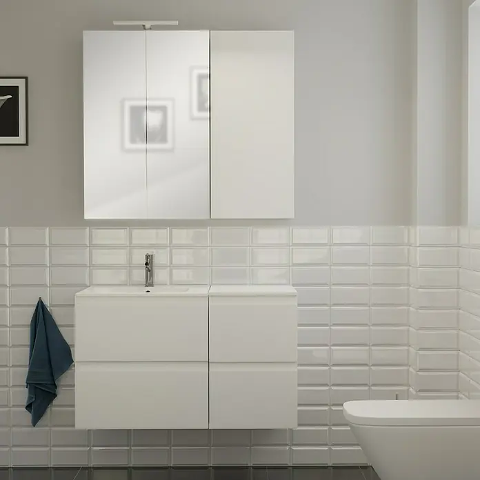 Camargue Espacio Badmöbel-Set i82 - 100 cm, Gama weiß matt - Modernes Badezimmer-Interieur mit einem weißen Waschbeckenunterschrank und einem Spiegelschrank, akzentuiert durch eine blaue Stoffserviette.