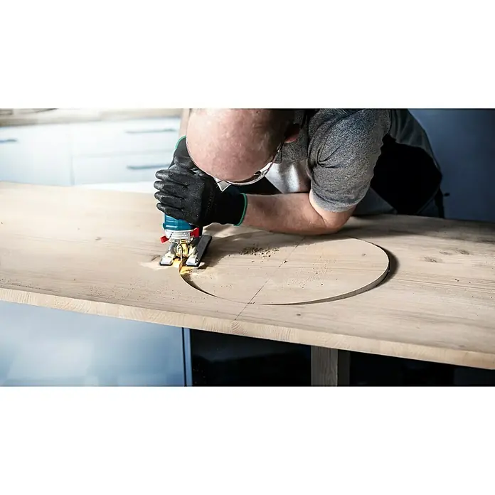 Bosch Stichsägeblätter Wood 2-Side Clean T308 BO - T-Schaft - Ein Handwerker, der mit einer Stichsäge ein kreisförmiges Loch in eine helle Holzplatte sägt. Schutzkleidung wird getragen.