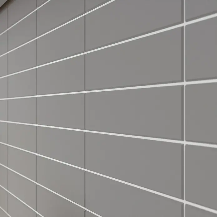 Modern Style Wandfliese Urban Gris - 7,5 x 30 cm, Grau, Matt - Nahaufnahme einer Wand mit grauen, rechteckigen Fliesen und weißen Fugen, die ein sauberes, modernes Design zeigt. Perfekt für stilvolle Räume.