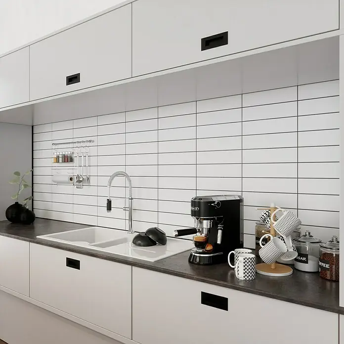 Modern Style Wandfliese Urban Blanco - 7,5 x 30 cm, Weiß, Matt - Eine moderne Küche mit einer Delonghi Espressomaschine, stilvollen Tassen und Vorratsgläsern auf einer dunklen Arbeitsplatte.