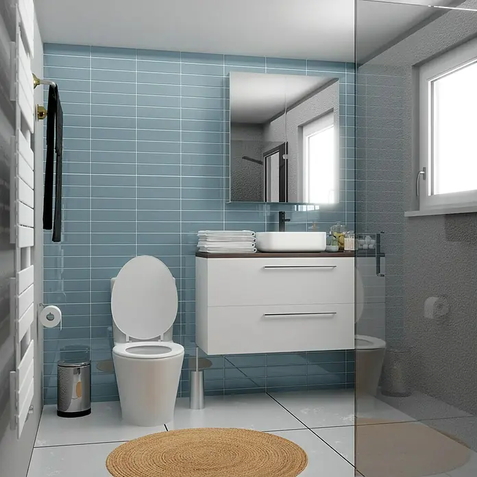 Modern Style Wandfliese Urban Oceano - 7,5 x 30 cm, Blau, Glänzend - Helles Badezimmer mit WC, Waschbecken und Spiegel. Elegante Armaturen, moderne Fliesen und ein runder Teppich schaffen eine stilvolle Atmosphäre.