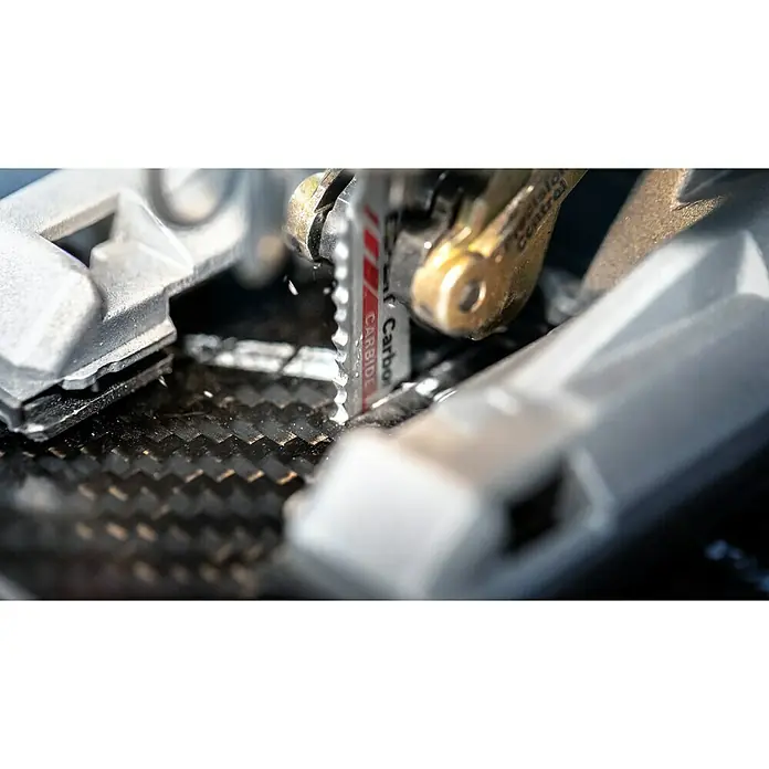 Bosch Expert Stichsägeblatt Carbon Fiber Clean T108 BHM - Länge: 92 mm, T-Schaft - Nahaufnahme einer Säge, die durch ein schwarzes, gewebtes Kohlenstoffmaterial schneidet, mit silbernen Halterungen.