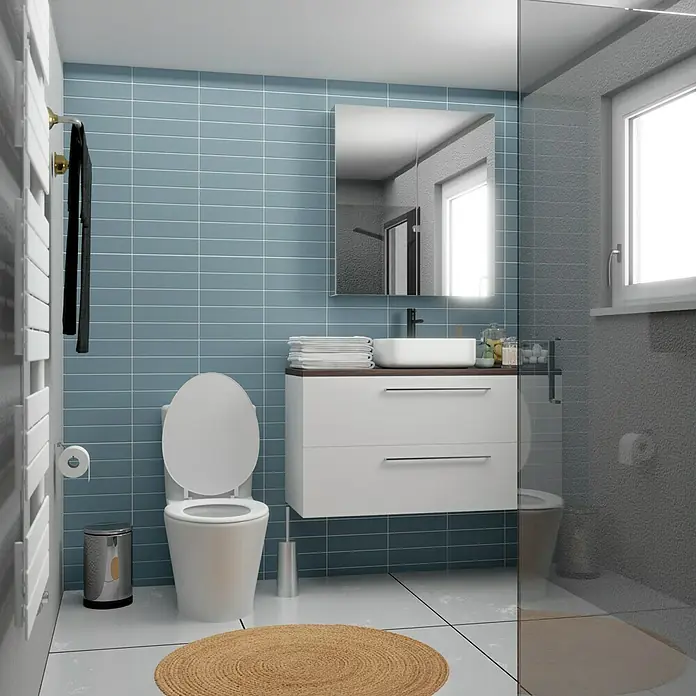 Modern Style Wandfliese Urban Oceano - 7,5 x 30 cm, Blau, Matt - Modernes Badezimmer mit Toilette, Waschbeckenunterschrank in Weiß und Spiegel. Blaue Fliesen und ein runder Teppich ergänzen das Design.