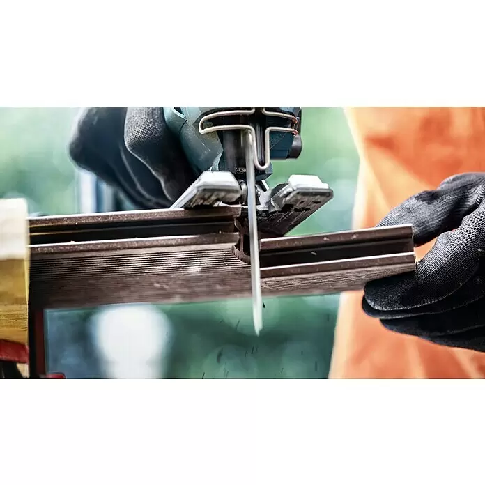 Bosch Stichsägeblätter Plastic Composites Clean T 301 CHM - T-Schaft - Nahaufnahme einer blauen Stichsäge, die einen dunkelbraunen geriffelten Holzbalken schneidet, gehalten von behandschuhten Händen.