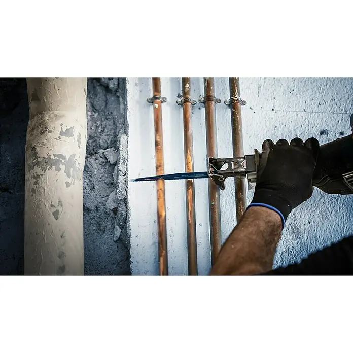 Bosch Expert Säbelsägeblatt Multi Material S 956 XHM - Länge: 150 mm - Ein Elektriker mit schwarzen Handschuhen schneidet mit einer Säbelsäge ein Kupferrohr in einem unfertigen Badezimmer.