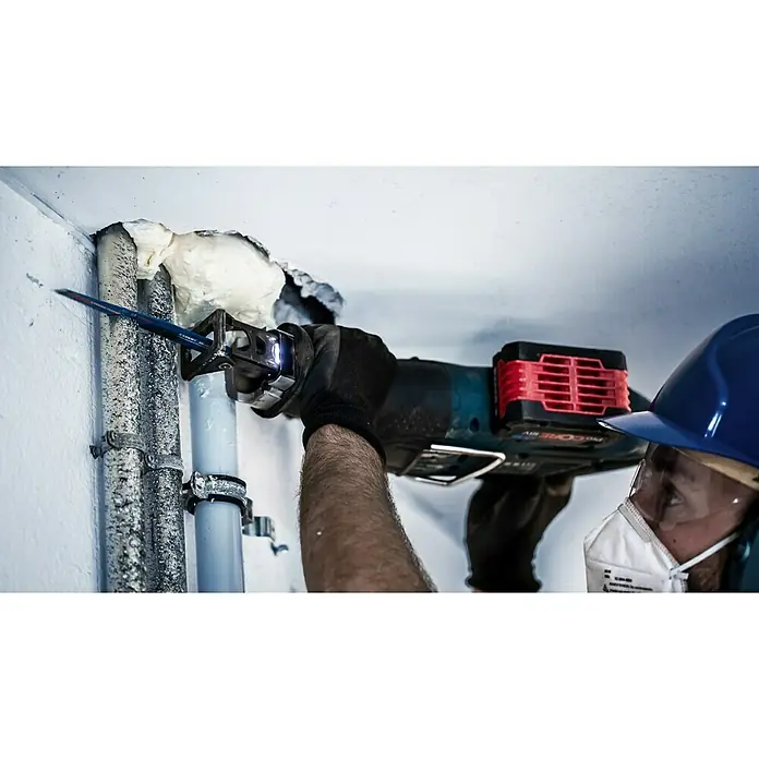 Bosch Expert Säbelsägeblatt Multi Material S 956 XHM - Länge: 150 mm - Rohre werden mit einer Bosch Akku-Säbelsäge mit LED-Licht für präzise Schnitte durchtrennt, während ein Arbeiter Schutzkleidung trägt.