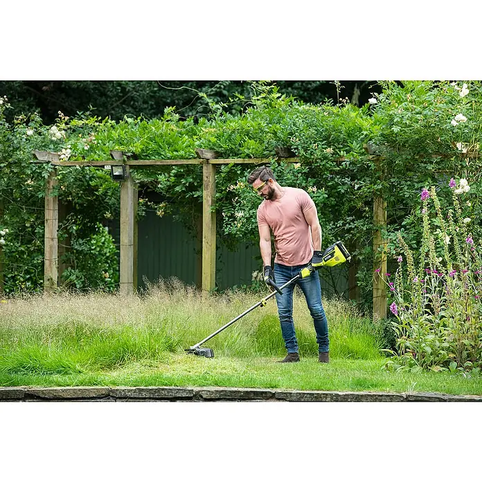 Ryobi Max Power Akku-Rasentrimmer RY36ELTX33A-0 - 36 V, Li-Ionen, Ohne Akku - Ein Mann benutzt einen Ryobi Rasentrimmer im Garten, um das Gras zu schneiden. Das Gerät ist gelb und schwarz und hat einen langen Schaft.