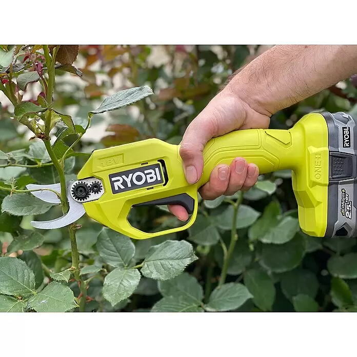 Ryobi ONE+ Akku-Gartenschere RY18SCA-0 + Artikelnr. 33198248 gratis hinzufügen* - 18 V, Li-Ionen, Ohne Akku, Max. Aststärke: 25 mm - Eine Hand hält eine gelb-graue Ryobi Akku-Astschere und schneidet einen Pflanzenstamm.