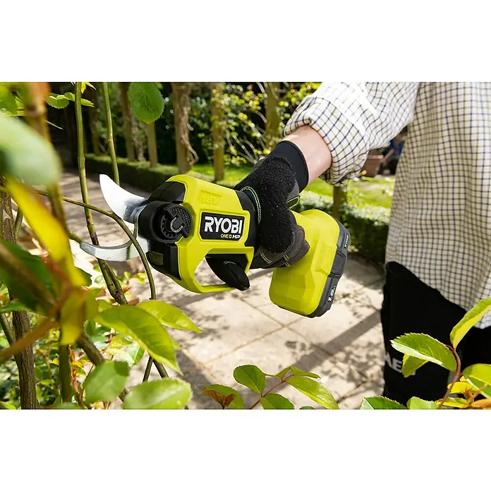 Ryobi ONE+HP Akku-Gartenschere RY18SCXA-0 - 18 V, Li-Ionen, Ohne Akku, Max. Aststärke: 28 mm - Nahaufnahme einer Akku-Gartenschere Ryobi ONE+ HP 18V beim Beschneiden eines Strauchs im Garten.