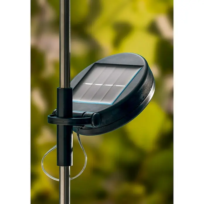 BAUHAUS Solarleuchte FeuerwerkHöhe: 90 cm, IP44, Lichtfarbe: RGB - Nahaufnahme einer Solarleuchte mit Solarpanel und silbernem Stab vor verschwommenem, grünem Hintergrund.