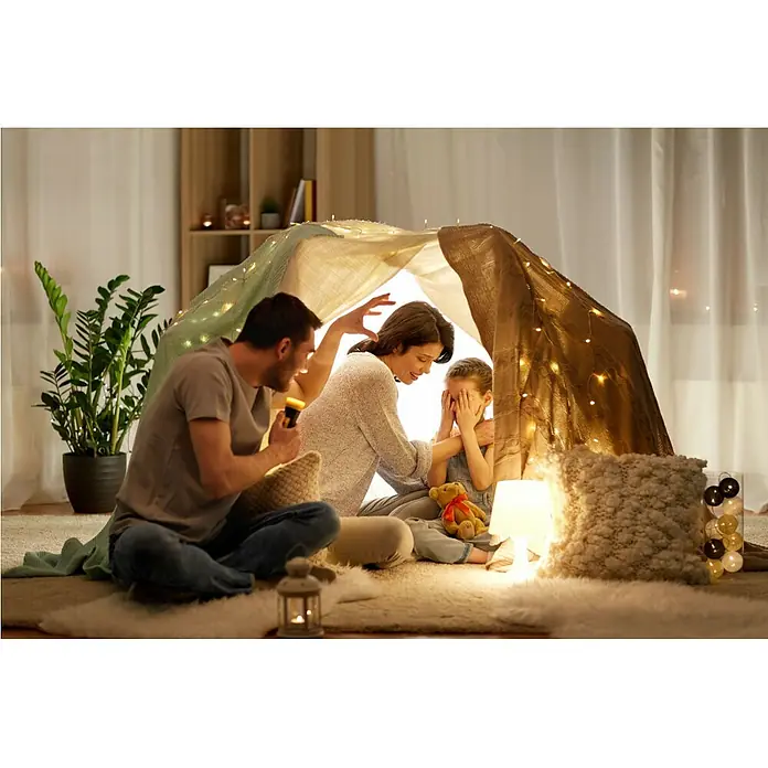 Garza Set de bombillas LED Filamento - E27, Blanco cálido, 1.050 lm, 8 W, 3 ud. - Familia con hija en tienda con luces. El padre sostiene una linterna, mientras la madre interactúa con la niña.