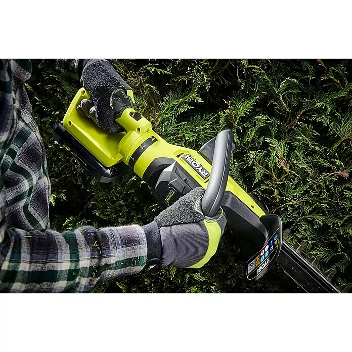 Ryobi Max Power Akku-Heckenschere RY36HTX65A-0 - 36 V, Li-Ionen, Ohne Akku - Handschuhtragende Person trimmt mit grün-schwarzem Ryobi Heckenschneider eine dichte Hecke.